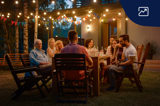 en grupp personer samlade runt ett bord utomhus en sommarkväll