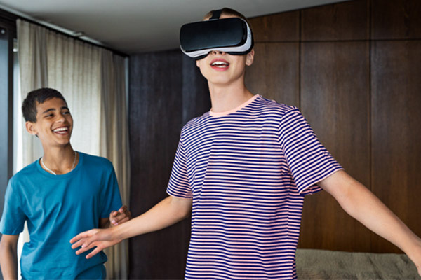 Två tonårskillar varav den ena bär VR-glasögon