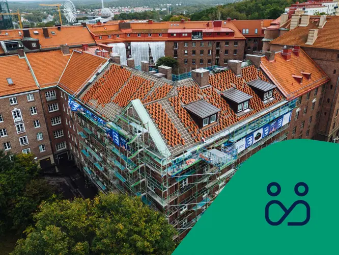 Vy över bostadshus med pågående takomläggning. Styrelseikon.