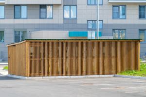 Modern träbyggnad för avfallshantering i brf.