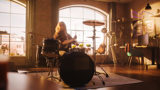 Kvinna spelar trummor i en lägenhet