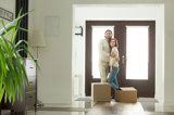 Ungt par står innan för dörren till sin nya bostadsrätt