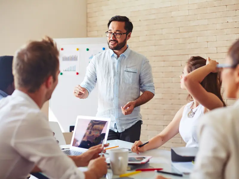 Man håller en presentation inför en mindre grupp människor