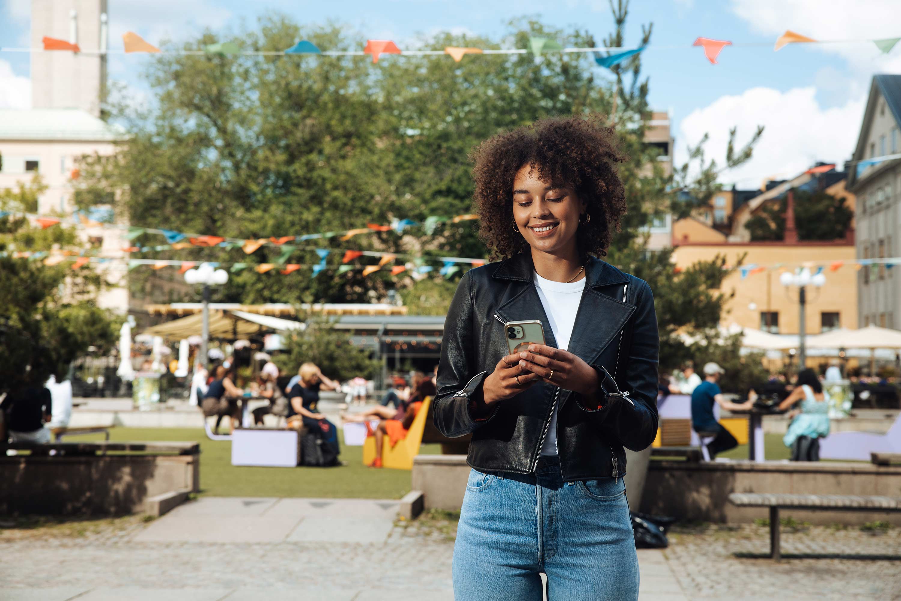 Glad kvinna tittar i sin mobil