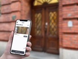Mobil hålls upp fram entré till en bostadsrättsförening