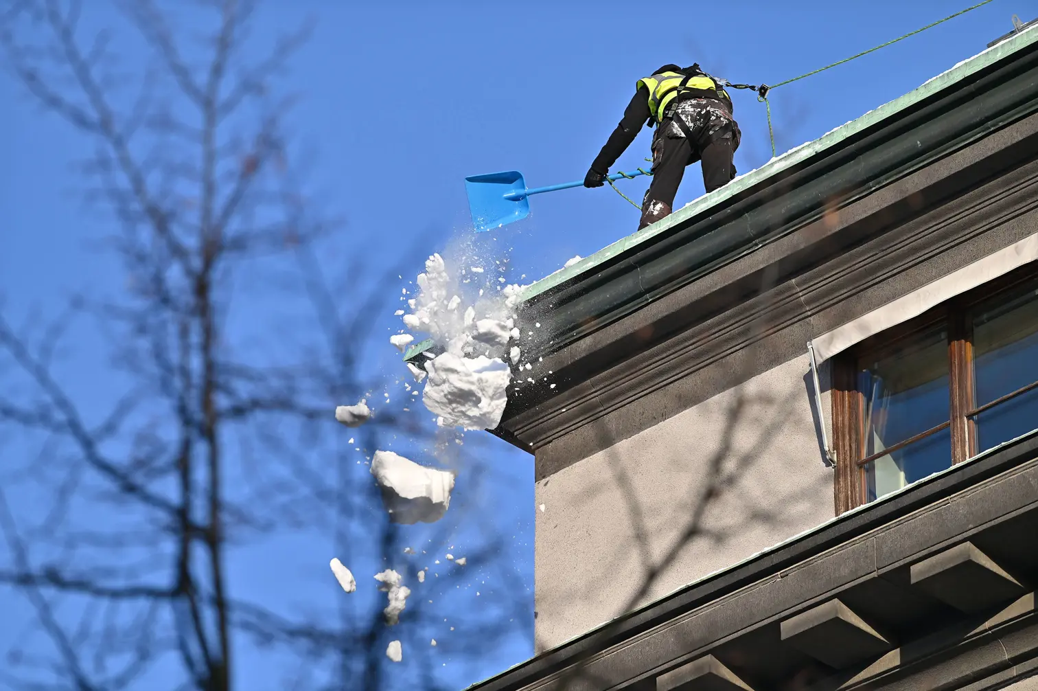 Snö skottas från tak i bostadsrättsförening