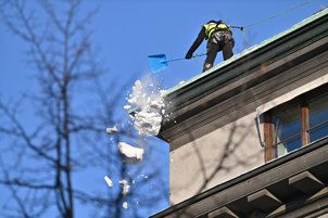 Snö skottas från tak i bostadsrättsförening