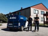 Två fastighetsskötare från SBC bär på trädgårdsredskap