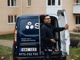 Fastighetsskötare från SBC stänger baklucka till bil