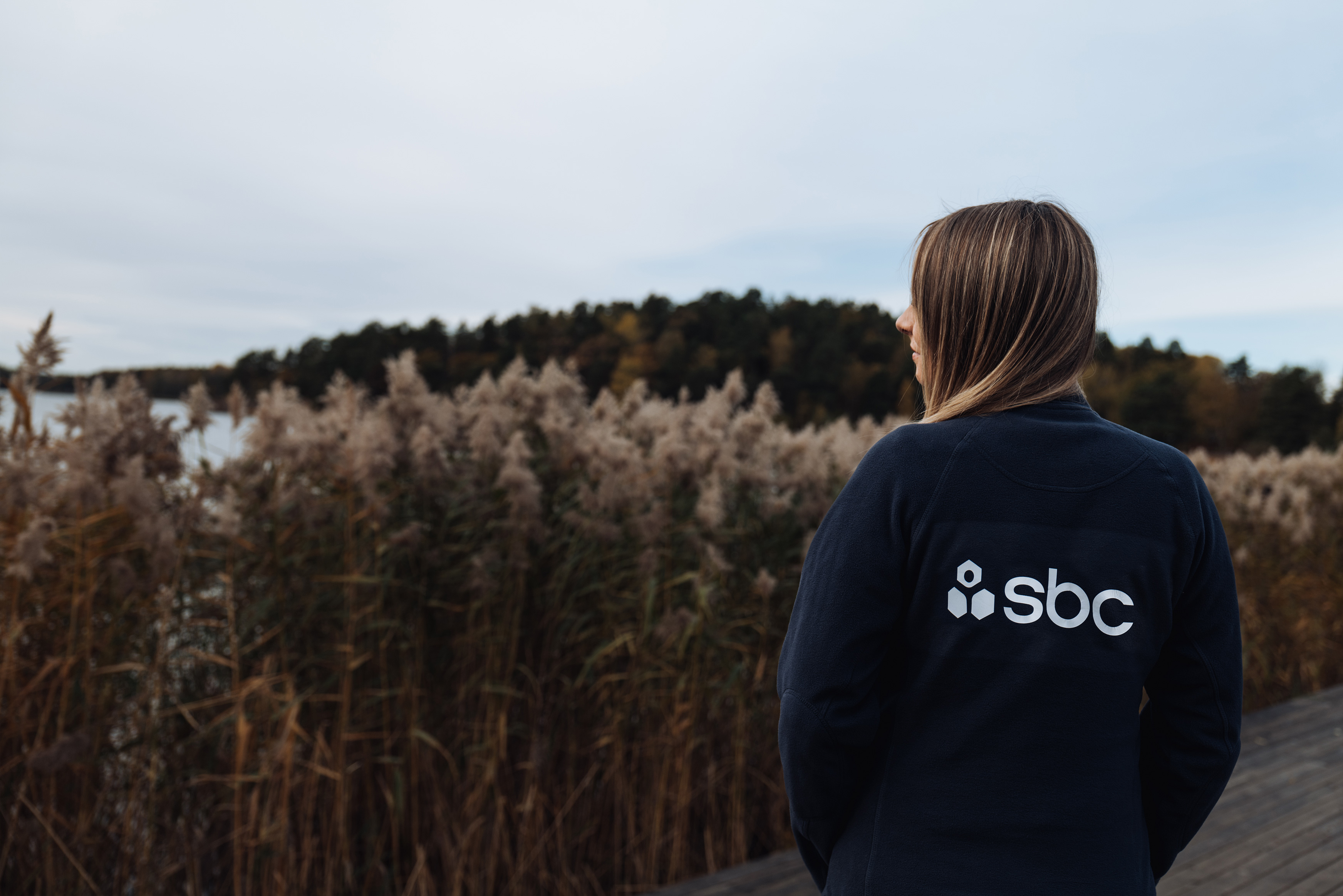Teknisk förvaltare står vid en sjö med vass
