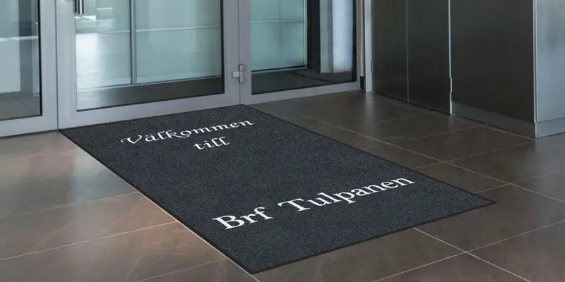 Entrématta med tryckt text som säger Välkommen till Brf Tulpanen
