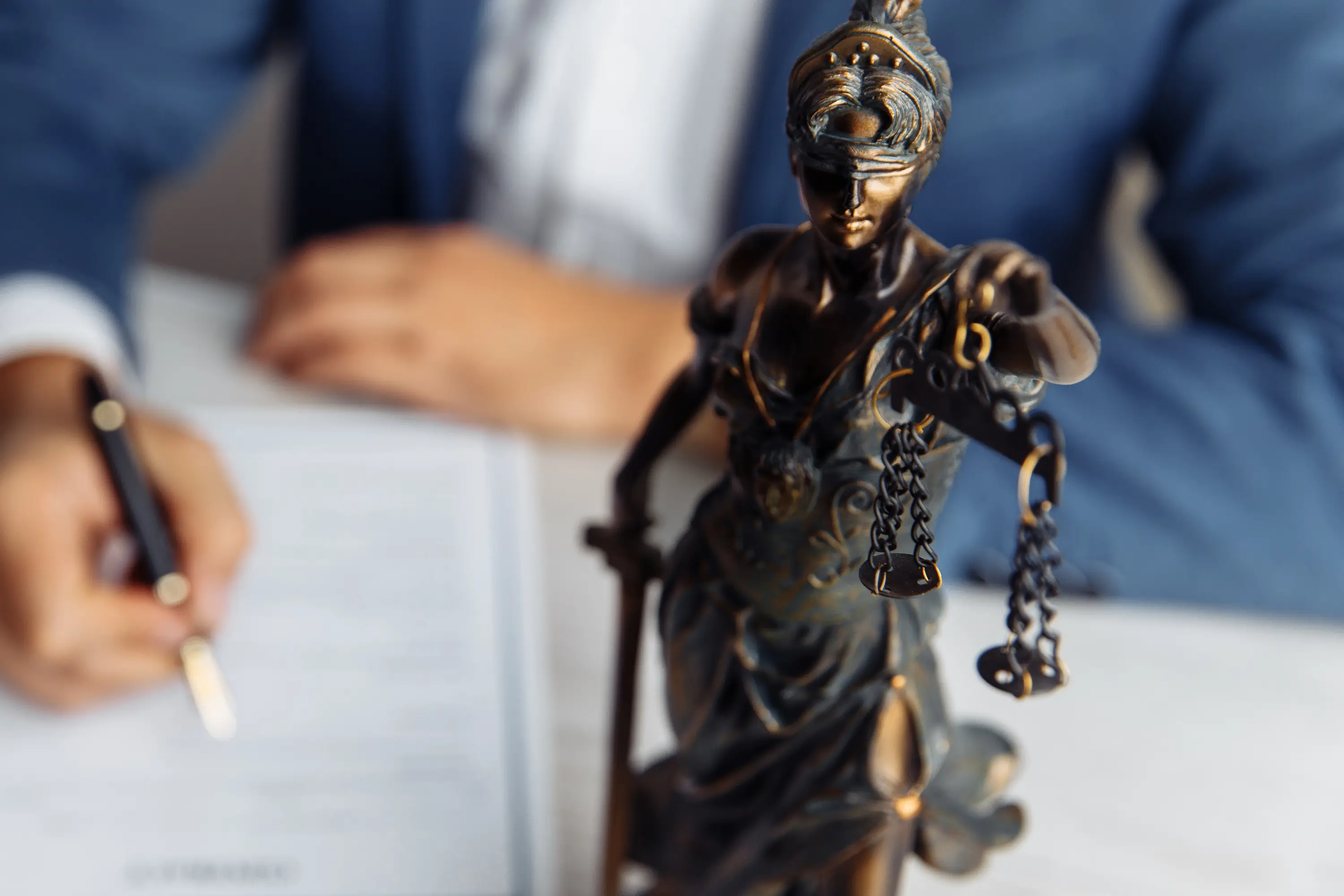 Staty brons föreställande fru Justitia som håller i en vågskål.