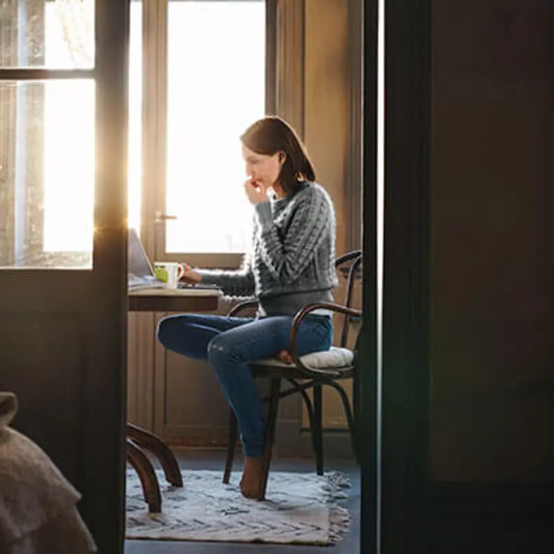 Kvinna som jobbar hemifrån sitt kök