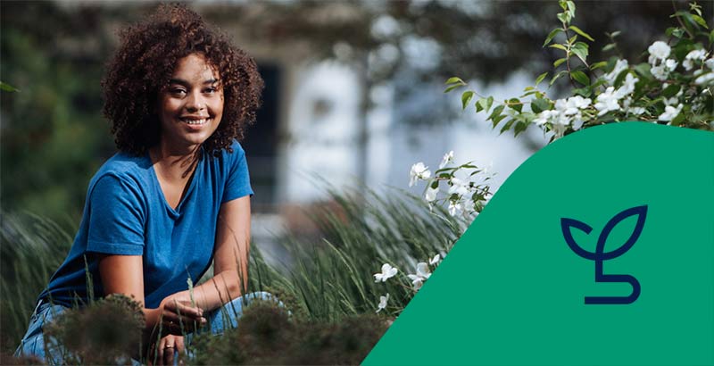 Kvinna sitter på huk i gräset med en fastighet i bakgrunden. Ikon för energi och miljö.