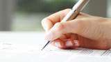 Hand skriver med en bläckpenna