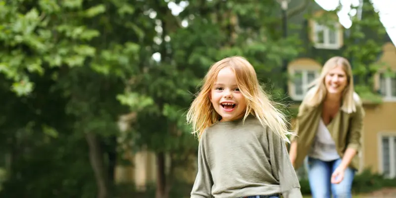 Mamma och dotter leker på innergård i brf
