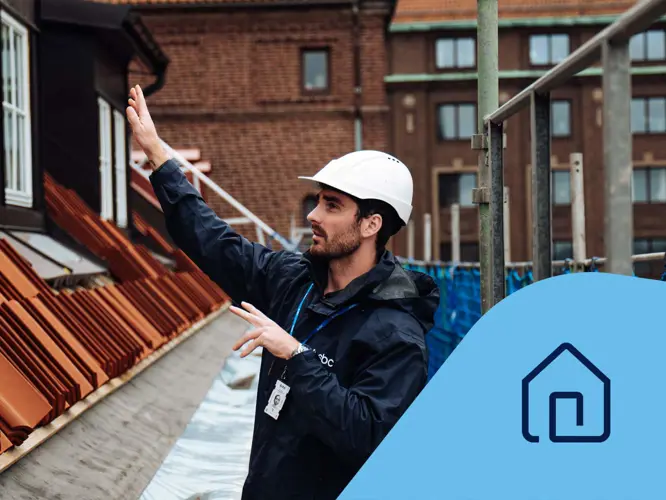 Projektledare Patrik står på en byggnadsställning och renoverar fastighetens tak. Fastighetsikon.