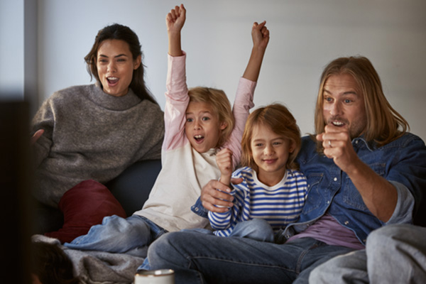 Glad barnfamilj har fredagsmys framför tvn