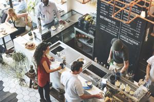 Kafé där barista serverar kaffe till gäster