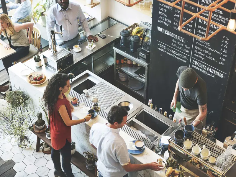 Kafé där barista serverar kaffe till gäster