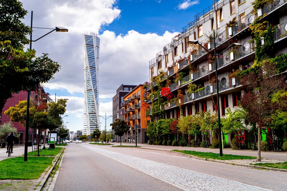 Färgglada lägenhetshus i Malmö med Turning Torso i bakgrunden.