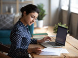 Kvinnlig ekonomisk förvaltare sitter framför sin dator