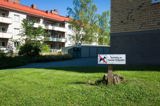 Skylt med texten "Rastning av hundar förbjuden". Står utanför en brf.